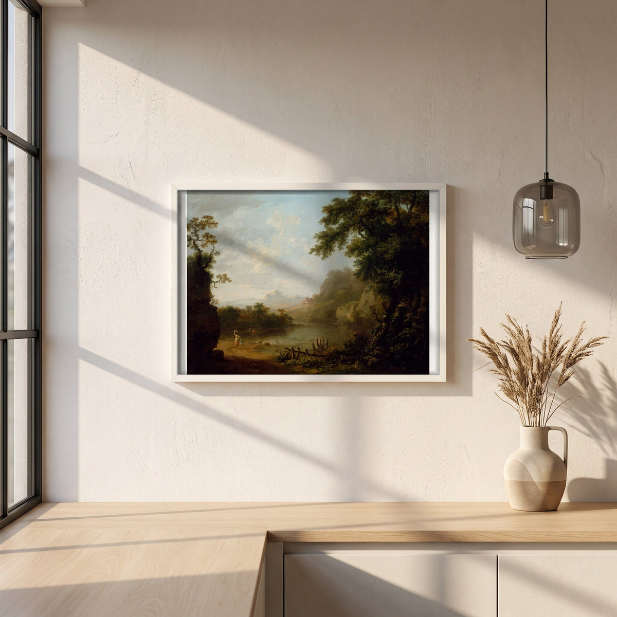 An Italianate Wooded River Landscape with Figures framed print in a white frame on a plaster wall above an oak worktop in a bright Scandinavian kitchen