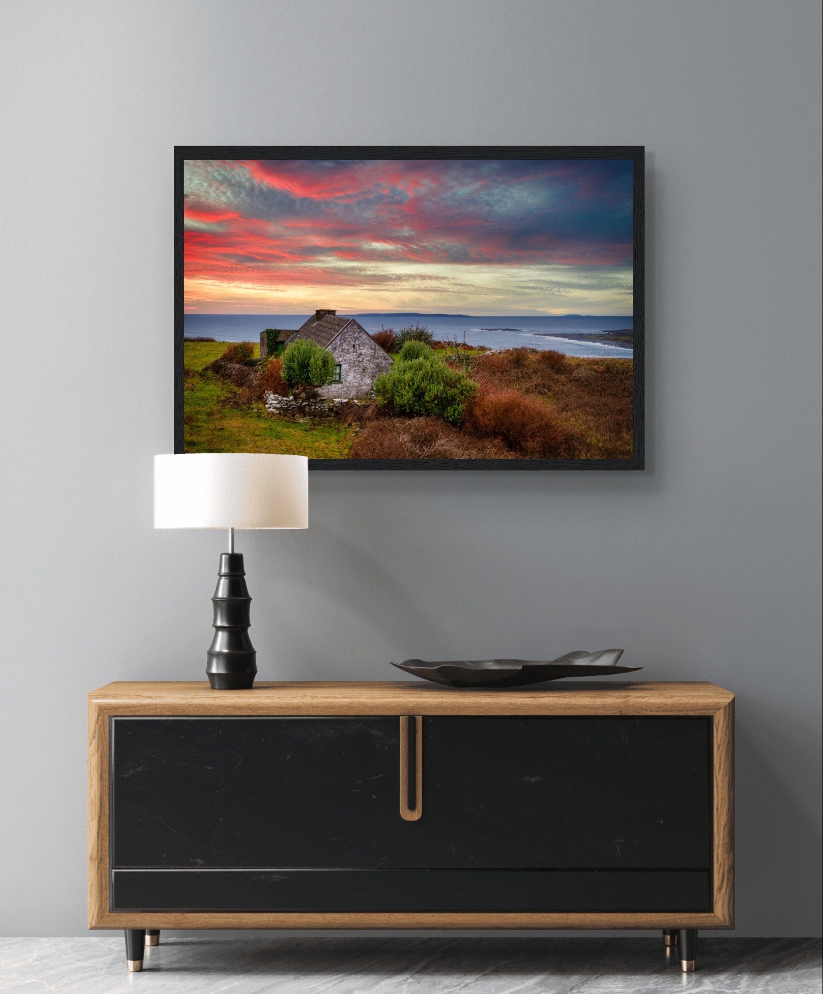 Art print: Serene sunset over Atlantic Ocean, Doolin, Co. Clare, Ireland. Small cottage nestled amid coastal cliffs, vibrant sky in hues of orange and pink, capturing tranquil beauty of Irish countryside.