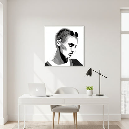 Sinéad O'Connor portrait print in a white frame above a white desk with a laptop and black lamp