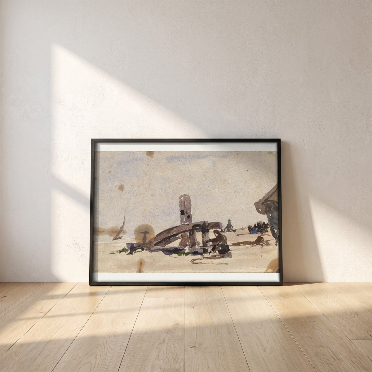 A Kneeling Man on the Beach framed print in a black frame leaning against a white plaster wall on oak floorboards in morning light