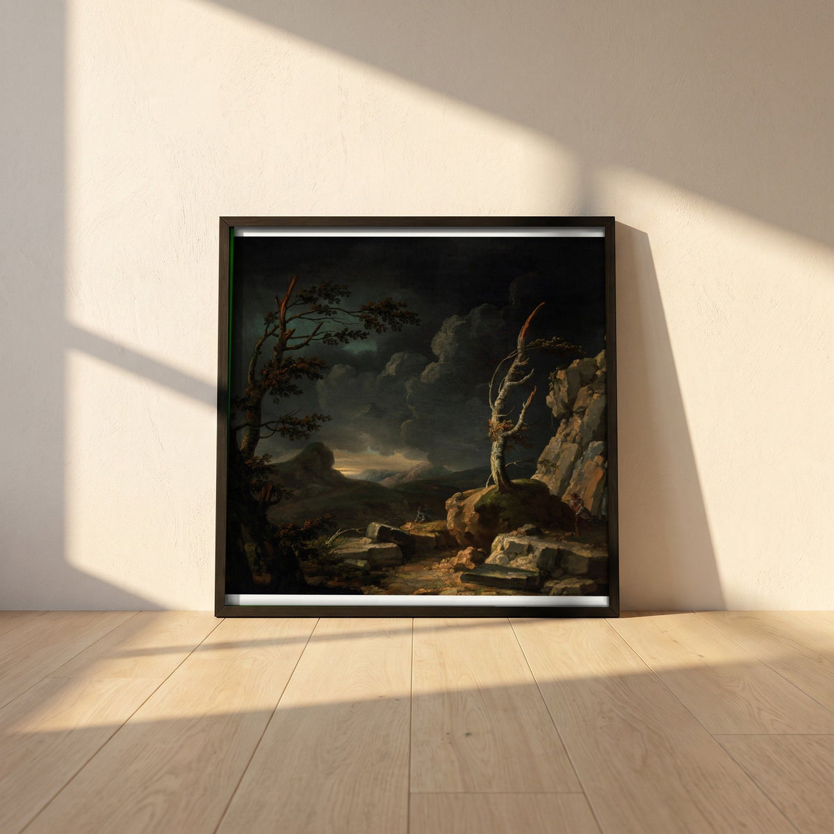 A Stormy Landscape framed print in a black frame leaning against a white plaster wall on oak floorboards in morning light