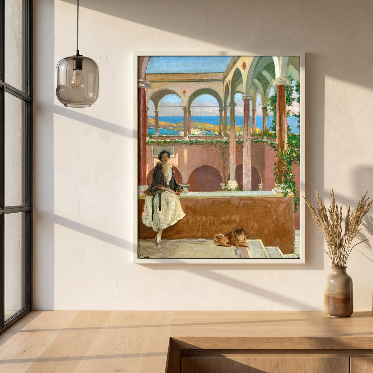 A Villa on the Riviera framed print in a white frame on a plaster wall above an oak worktop in a bright Scandinavian kitchen