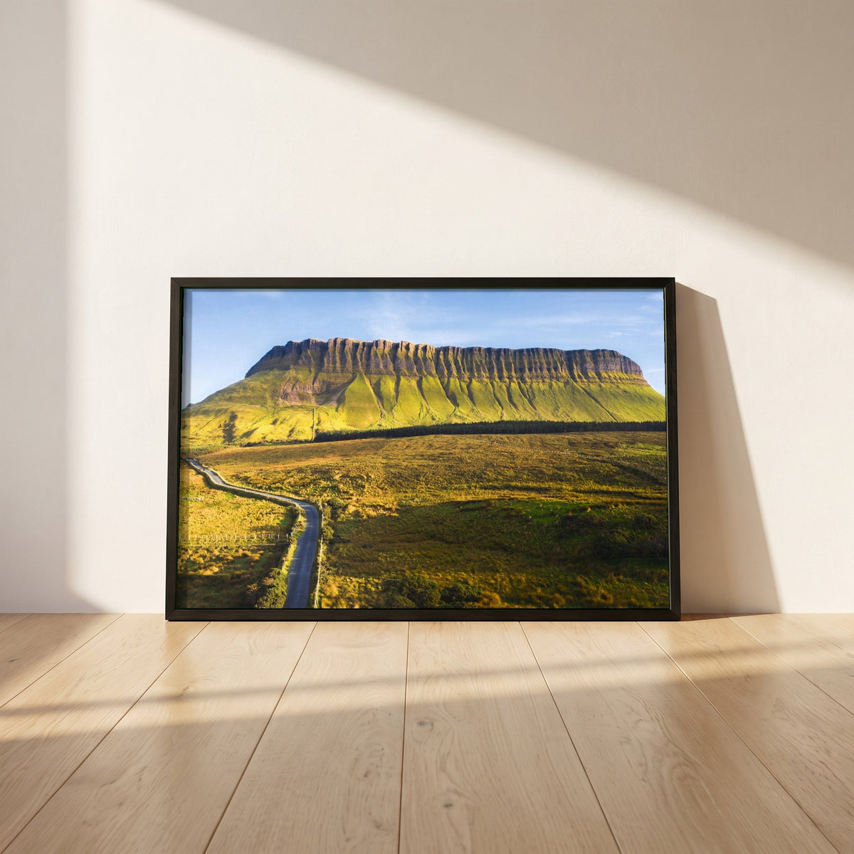 Benbulben, Sligo framed print in a black frame leaning against a white plaster wall on oak floorboards in morning light