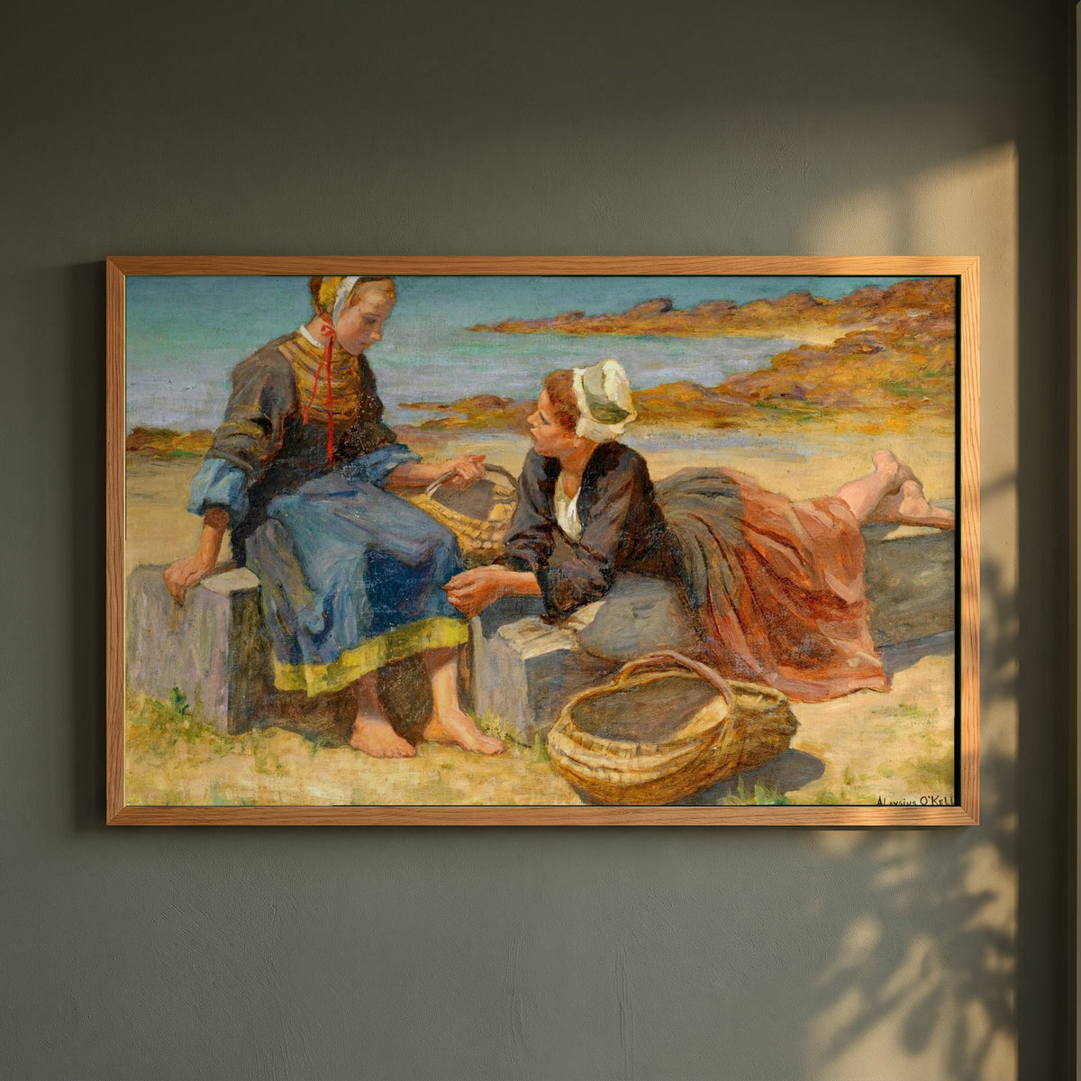 Breton Girls On a Beach By Irish Artist Aloysius O'Kelly framed print in a natural oak frame on a dark green wall beside a window, dappled plant shadow