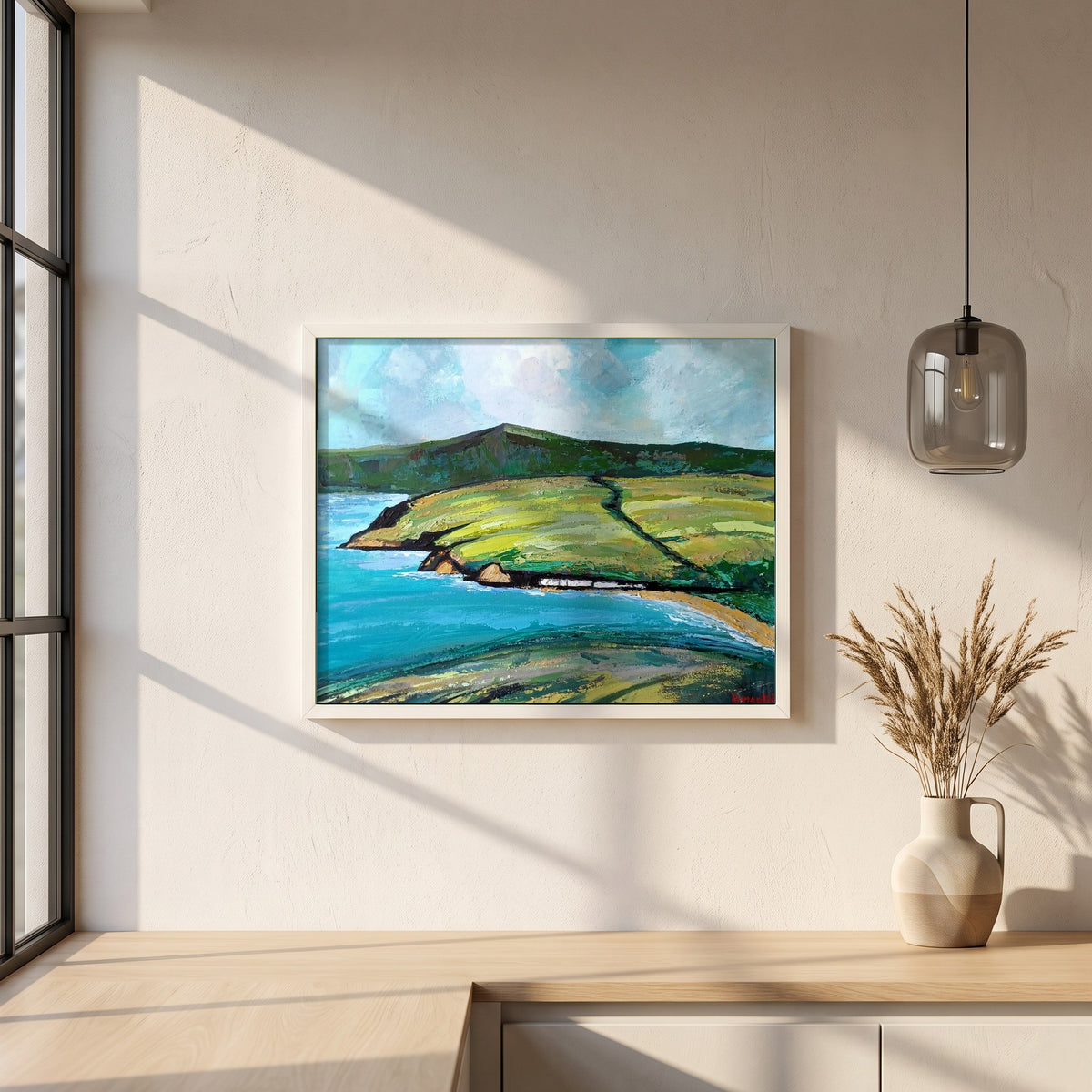 Cushendun framed print in a white frame on a plaster wall above an oak worktop in a bright Scandinavian kitchen