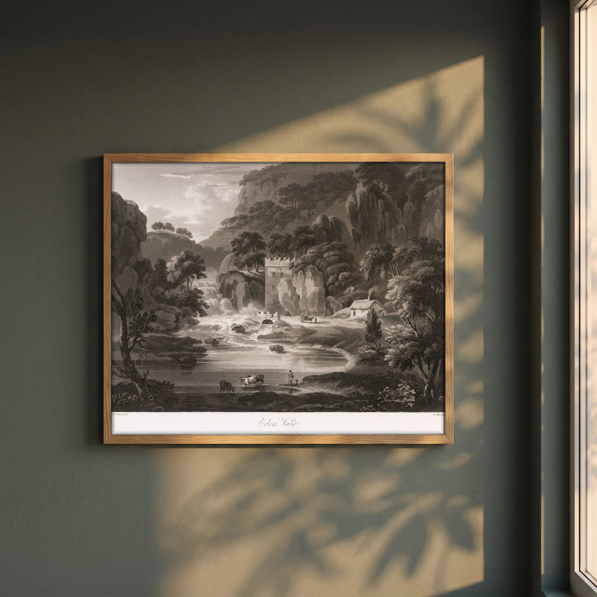 Eden Vale by Thomas Sautelle Roberts Art Print framed print in a natural oak frame on a dark green wall beside a window, dappled plant shadow