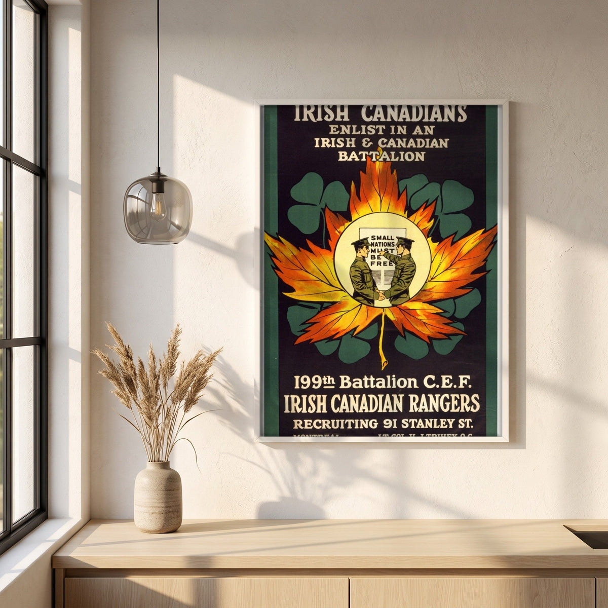 Enlist in an Irish & Canadian Battalion (1915) framed print in a white frame on a plaster wall above an oak worktop in a bright Scandinavian kitchen