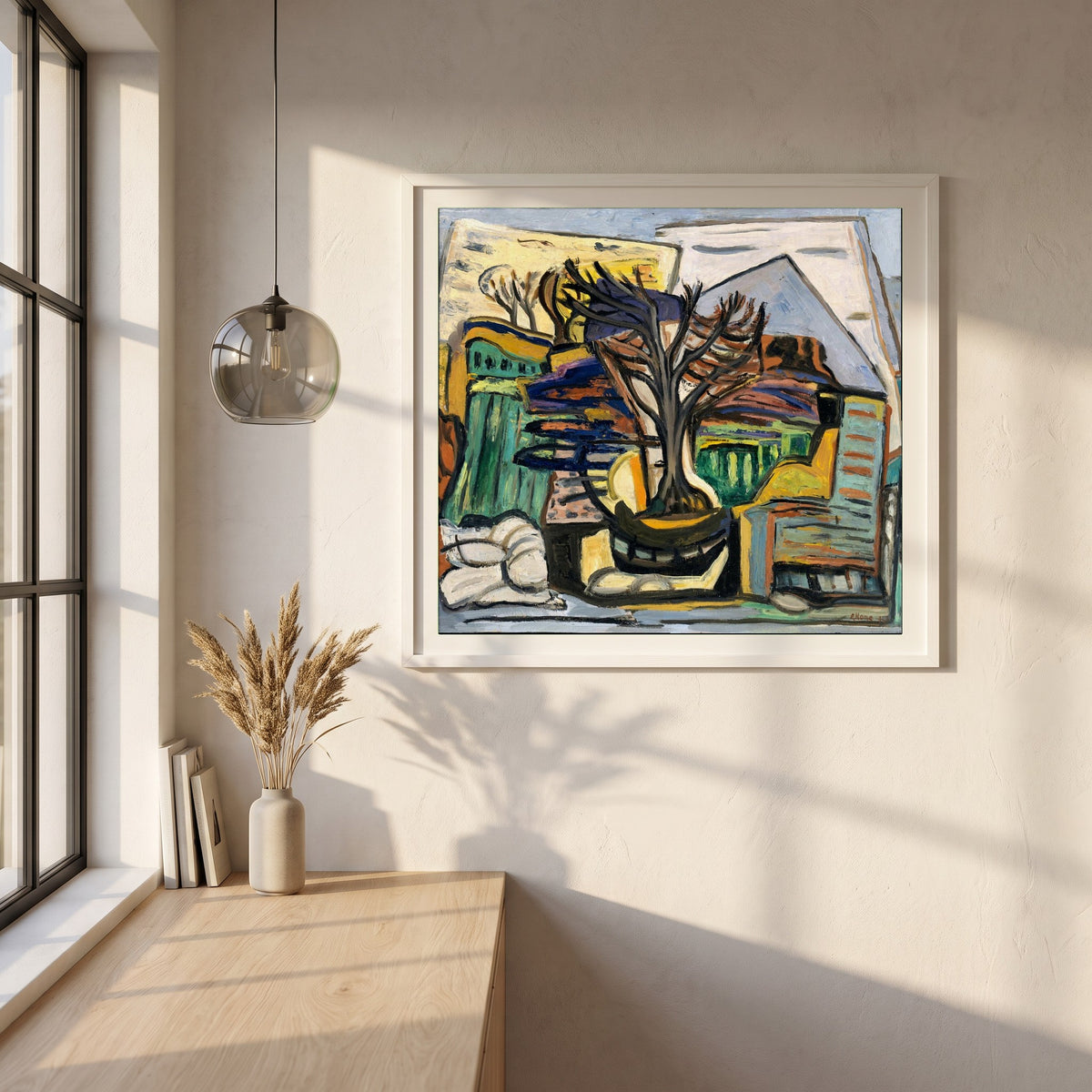 A Landscape with a Tree framed print in a white frame on a plaster wall above an oak worktop in a bright Scandinavian kitchen