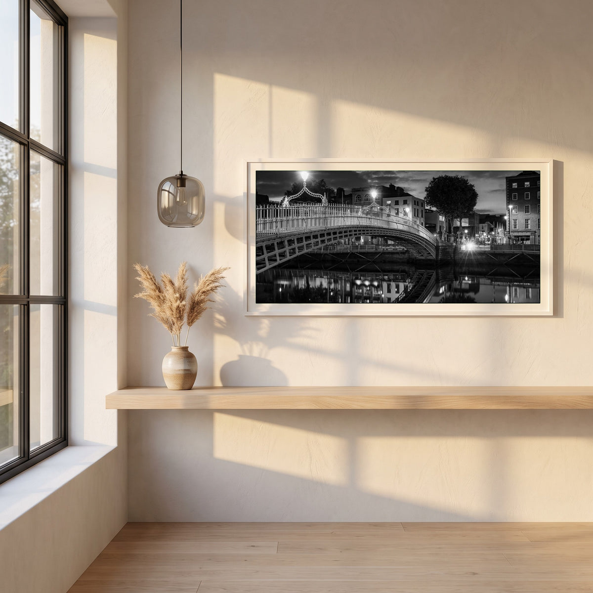 Night View of Ha'penny Bridge framed print in a white frame on a plaster wall above an oak worktop in a bright Scandinavian kitchen