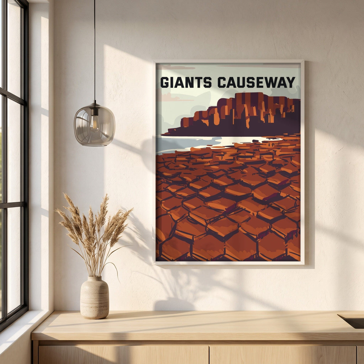 Giant's Causeway retro travel poster in a white frame on a plaster wall above an oak worktop in a bright Scandinavian kitchen