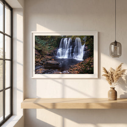 Glenariff Waterfall framed print in a white frame on a plaster wall above an oak worktop in a bright Scandinavian kitchen