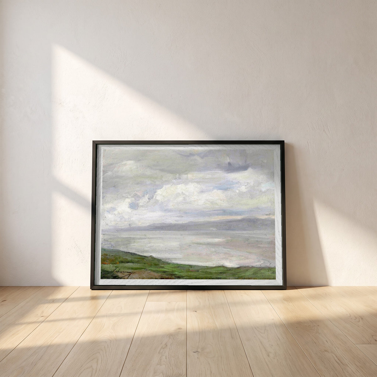Island Magee framed print in a black frame leaning against a white plaster wall on oak floorboards in morning light