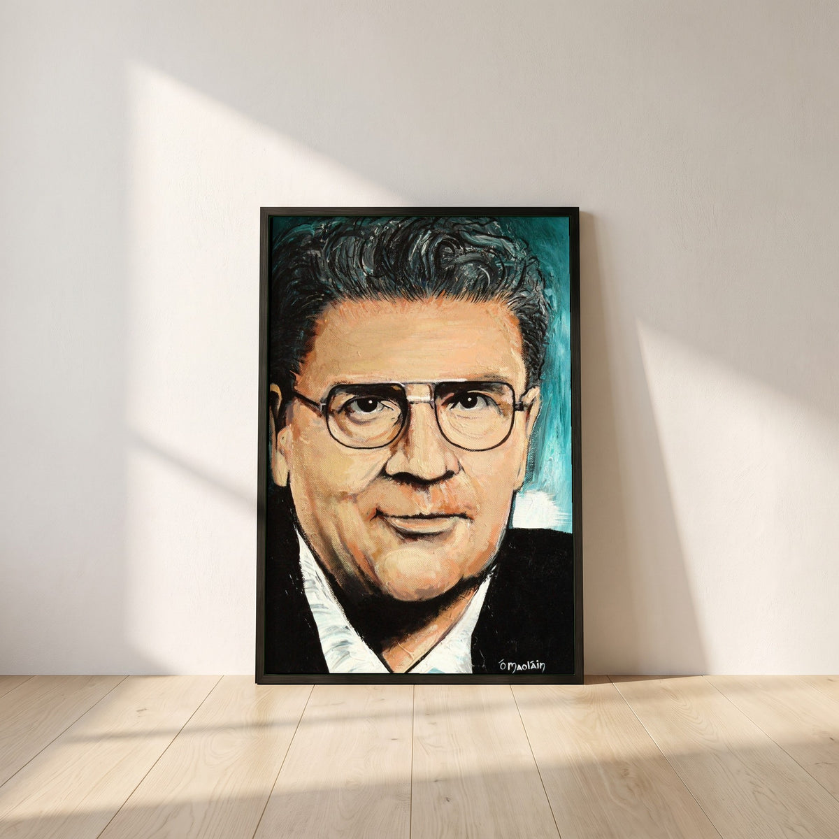 John Hume framed print in a black frame leaning against a white plaster wall on oak floorboards in morning light