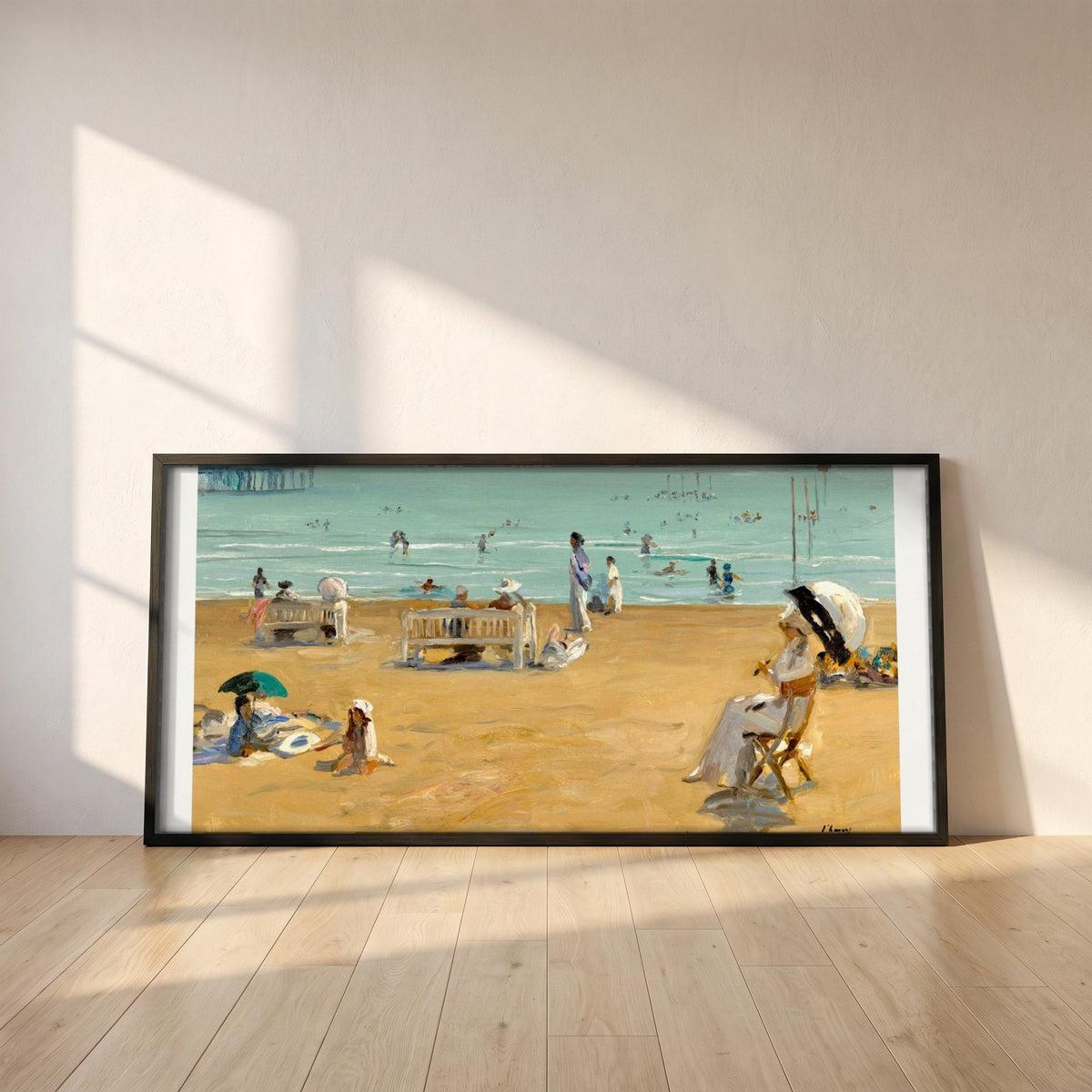 The Bathing Hour, Lido, Venice by John Lavery framed print in a black frame leaning against a white plaster wall on oak floorboards in morning light