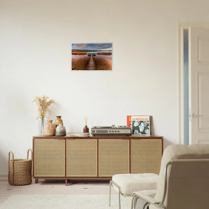 Old Jetty, Lough Derg framed print above a rattan-fronted sideboard in a neutral room