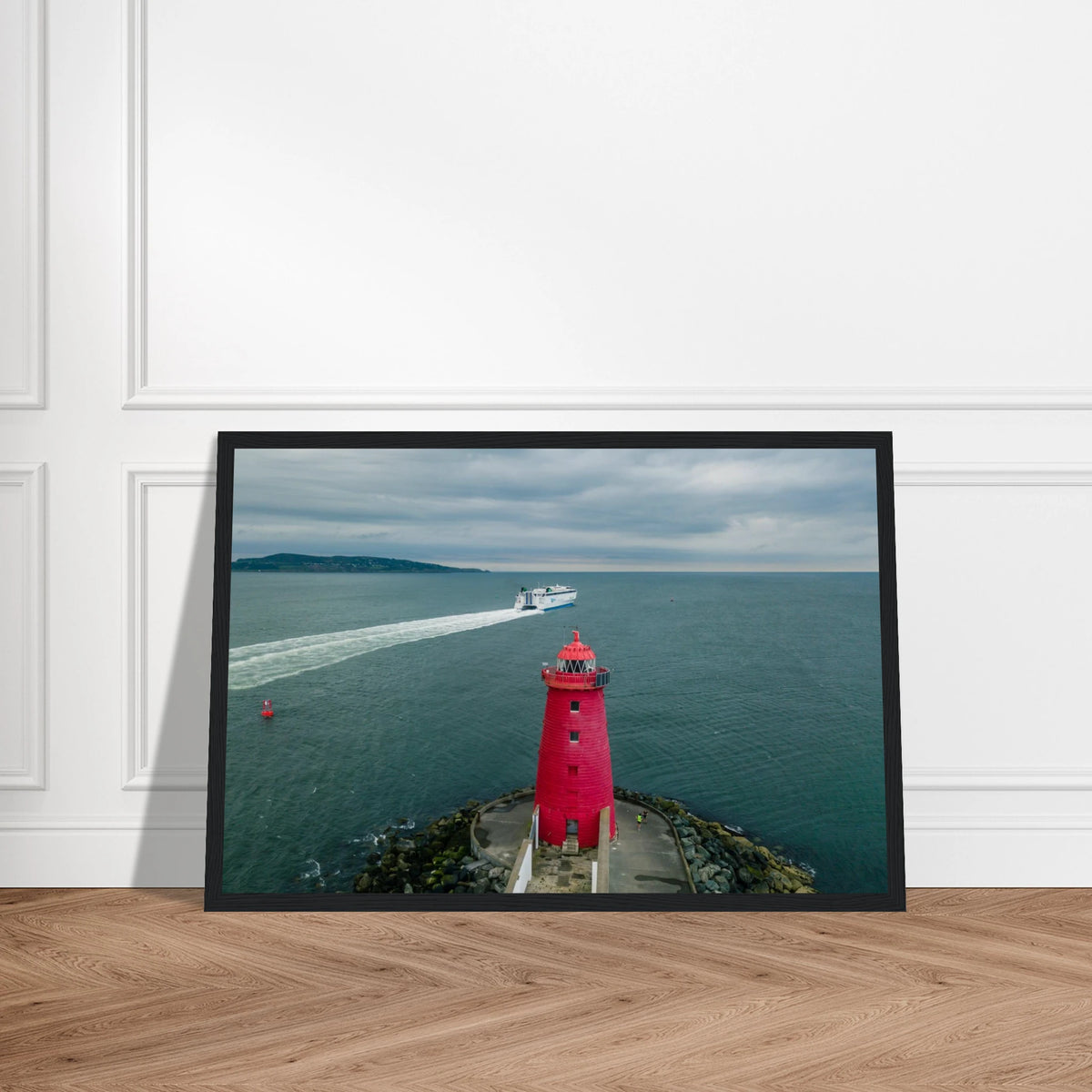 Poolbeg Lighthouse, Dublin Bay photo in a black frame on a wooden floor, straight-on view