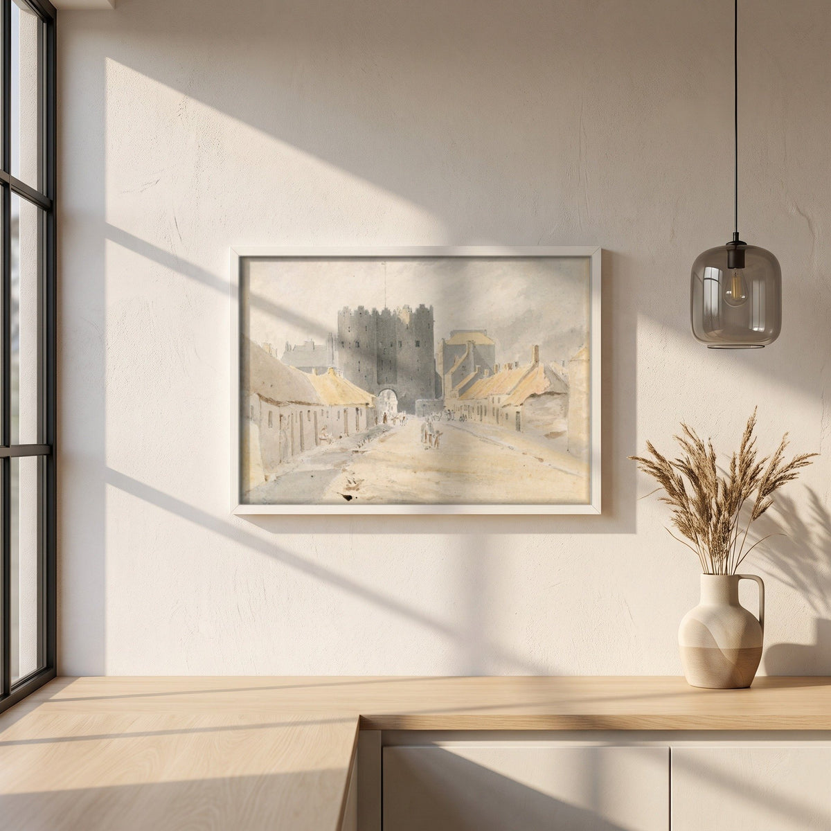 Saint Lawrence's Gate, Drogheda (1819) framed print in a white frame on a plaster wall above an oak worktop in a bright Scandinavian kitchen