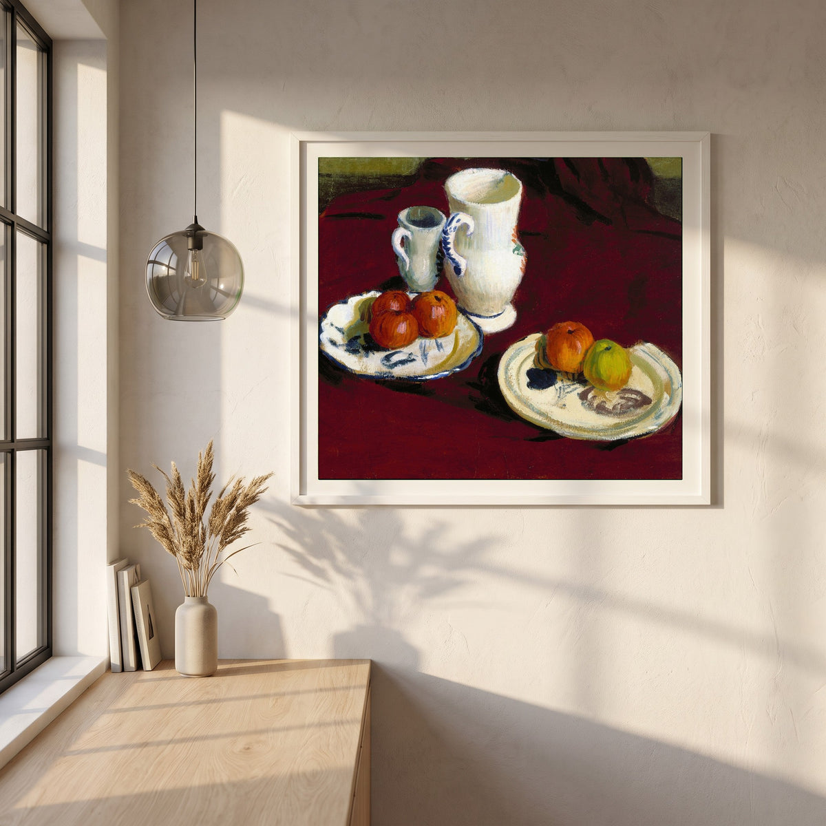 Apples and Breton Pots framed print in a white frame on a plaster wall above an oak worktop in a bright Scandinavian kitchen