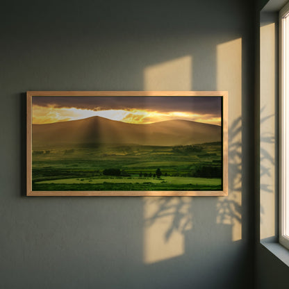 Sugarloaf Mountain, Wicklow framed print in a natural oak frame on a dark green wall beside a window, dappled plant shadow
