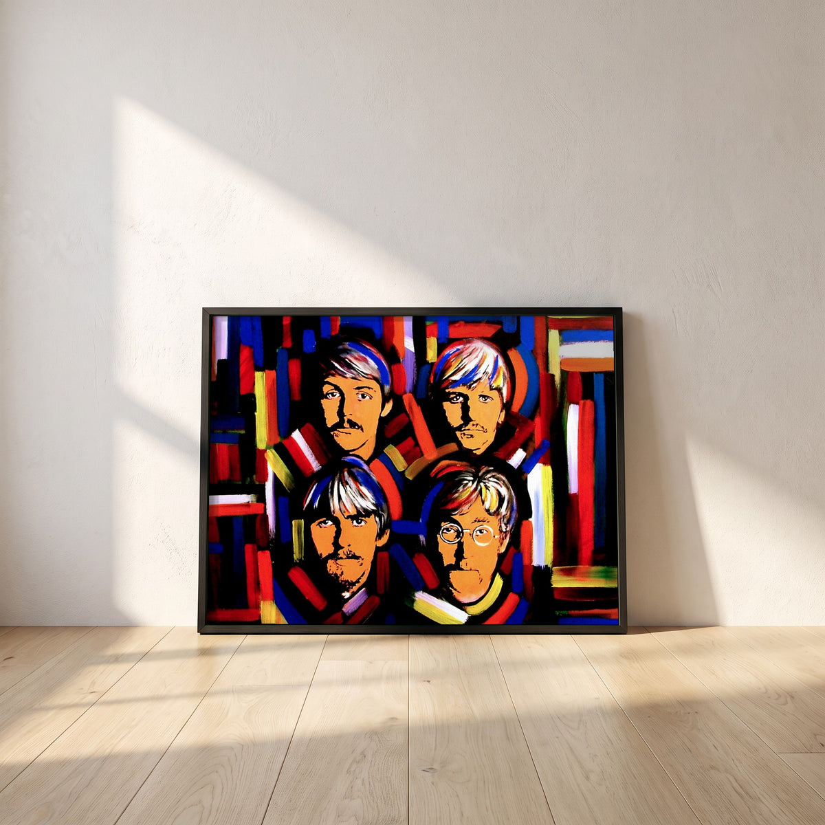 The Beatles Fab Four framed print in a black frame leaning against a white plaster wall on oak floorboards in morning light