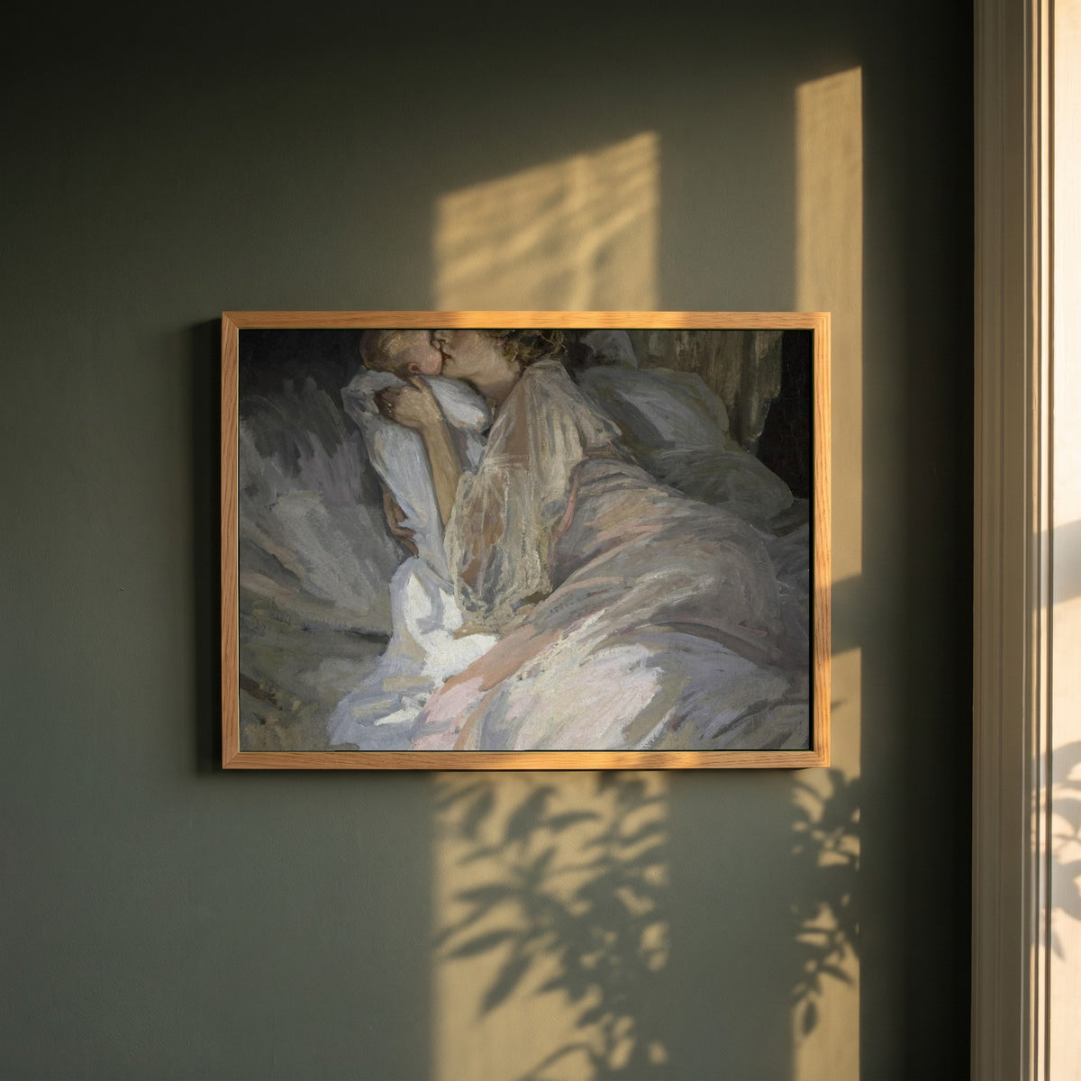 The Mother framed print in a natural oak frame on a dark green wall beside a window, dappled plant shadow