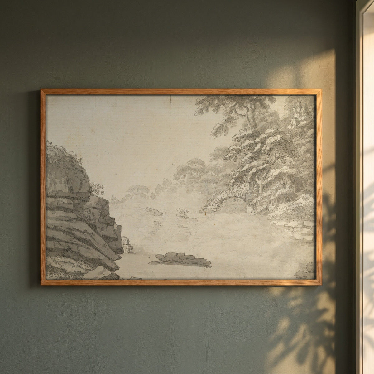 The Salmon Leap, Leixlip framed print in a natural oak frame on a dark green wall beside a window, dappled plant shadow