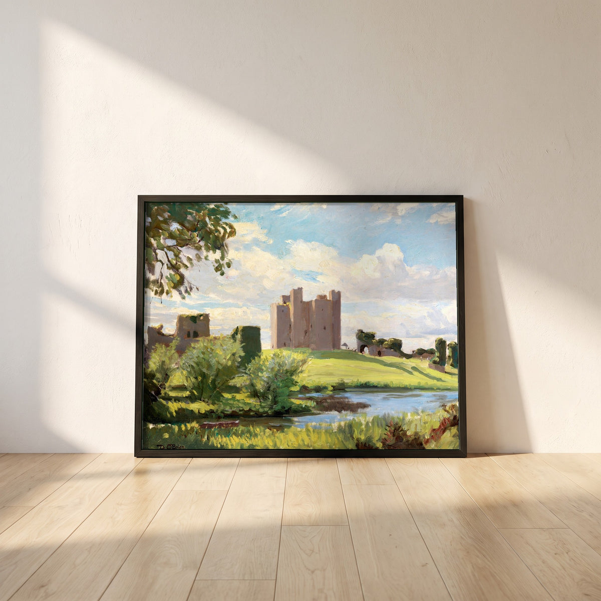Trim Castle framed print in a black frame leaning against a white plaster wall on oak floorboards in morning light