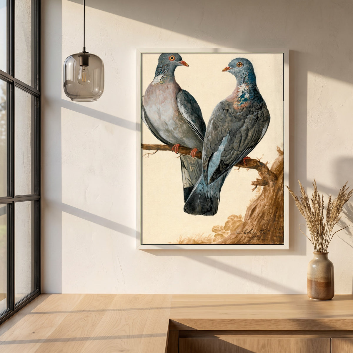 Two Wood Pigeons framed print in a white frame on a plaster wall above an oak worktop in a bright Scandinavian kitchen