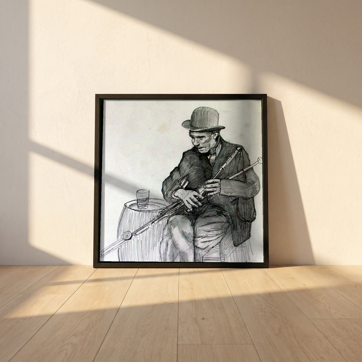 Uilleann Piper framed print in a black frame leaning against a white plaster wall on oak floorboards in morning light